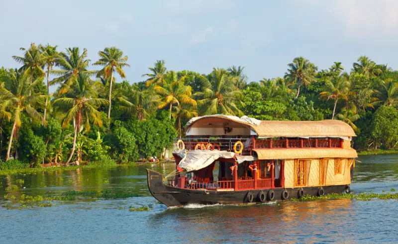 Discover the charm of a Nileshwar houseboat—where tranquil backwaters, village life, and rich Kerala flavors blend into a luxurious escape.